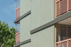 The soft green tiles of the Kennedy Gardens 'Orchidea' building in Vienna are contrasted against salmon pink balcony details