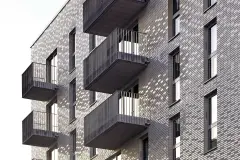 Close-up of ceramic facade with grey StoCera ceramic tiles and windows, new Sportlerhaus in Hamburg.