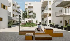 Residential buildings in the Rivus Vivere urban neighbourhood from the outside, with seating areas